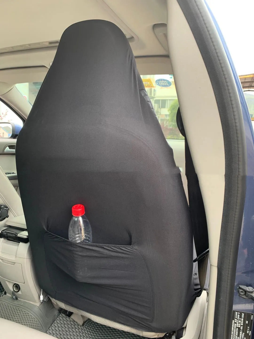Black quilted automotive seat cover made of PU and polyester fabric on a car seat.