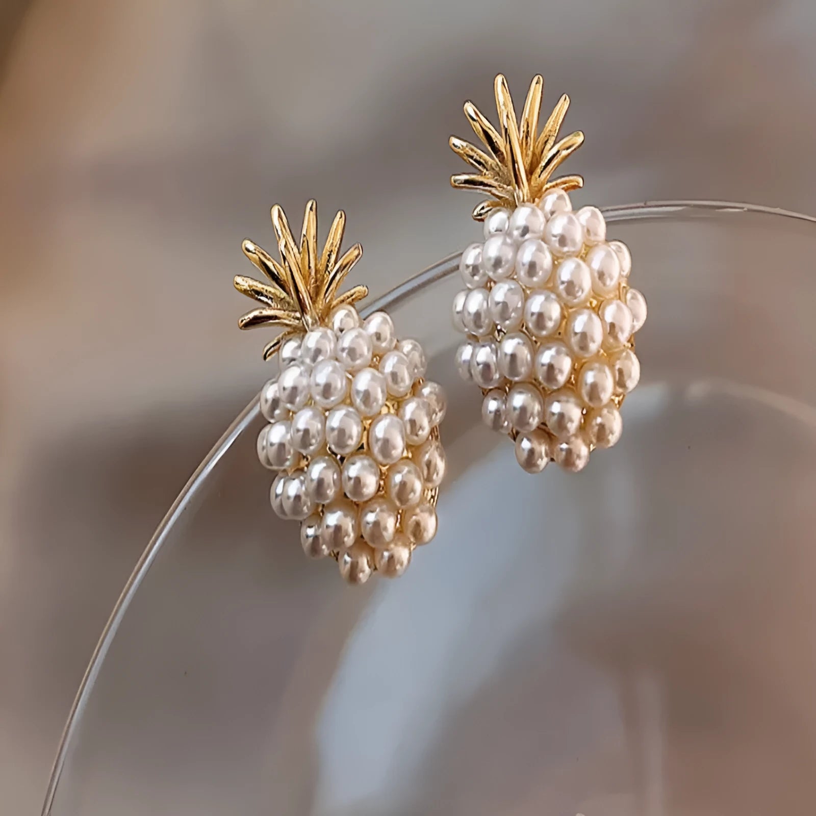 Gold pineapple and starfish pearl Korean style drop earrings with alloy electroplating and inlaid gems.