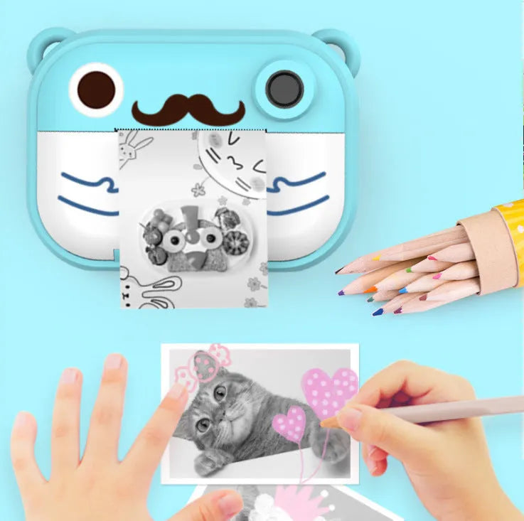 Pink C3 instant print digital camera with 2.4-inch screen, placed alongside included printing paper, stickers, and accessory pack