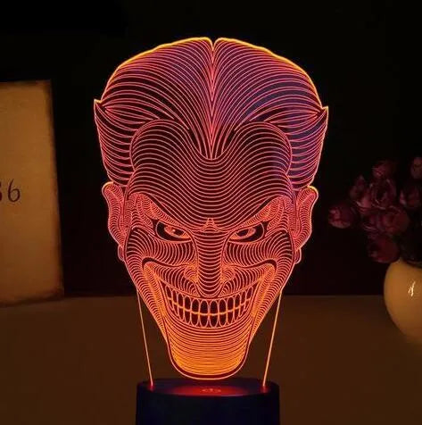 USB-powered 3D acrylic LED lamp displaying multiple colours on a desk with remote control.