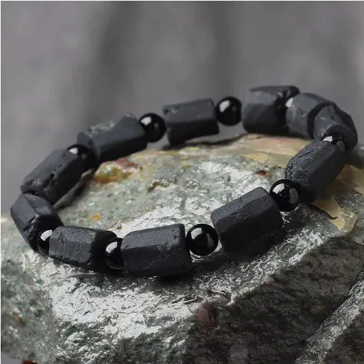 Black tourmaline rough stone bracelet on a wrist, showing natural texture and 10mm size