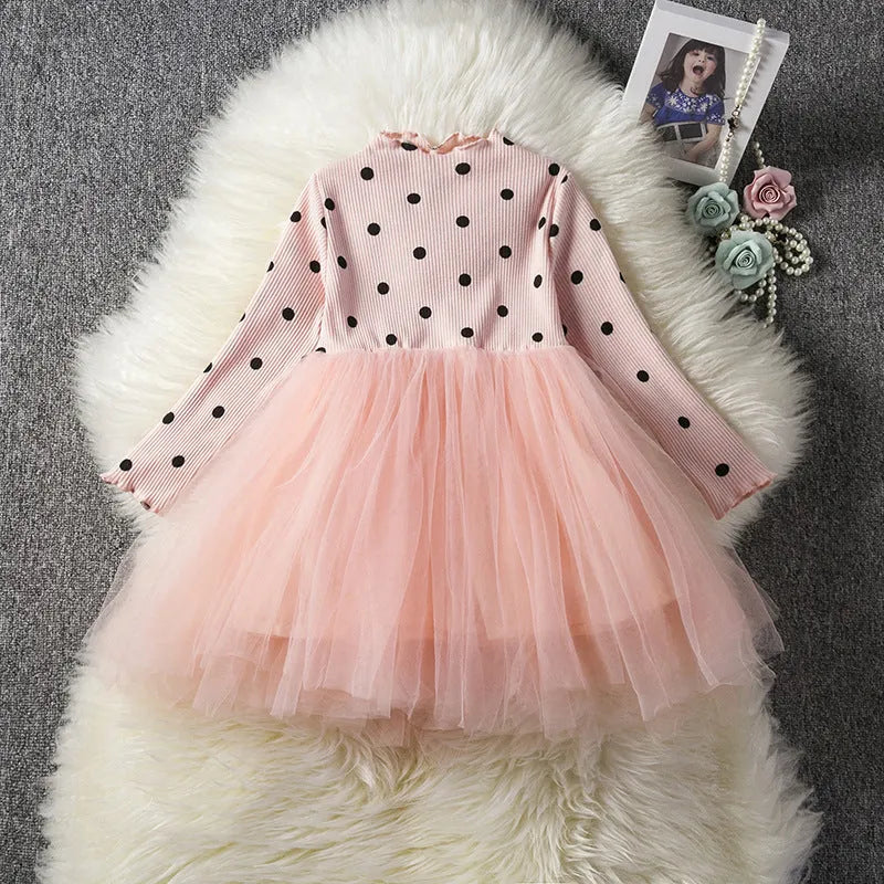 Baby girl wearing a long sleeve black tutu lace dress for a first birthday party.