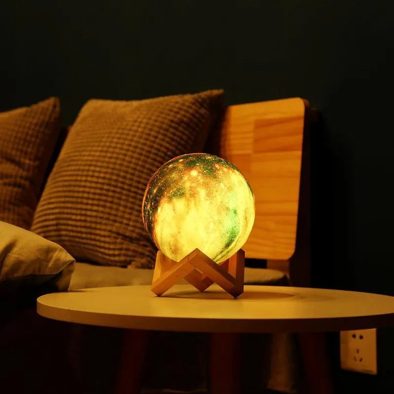 3D-printed spherical moon night light glowing with colour-changing LEDs on a dark surface.