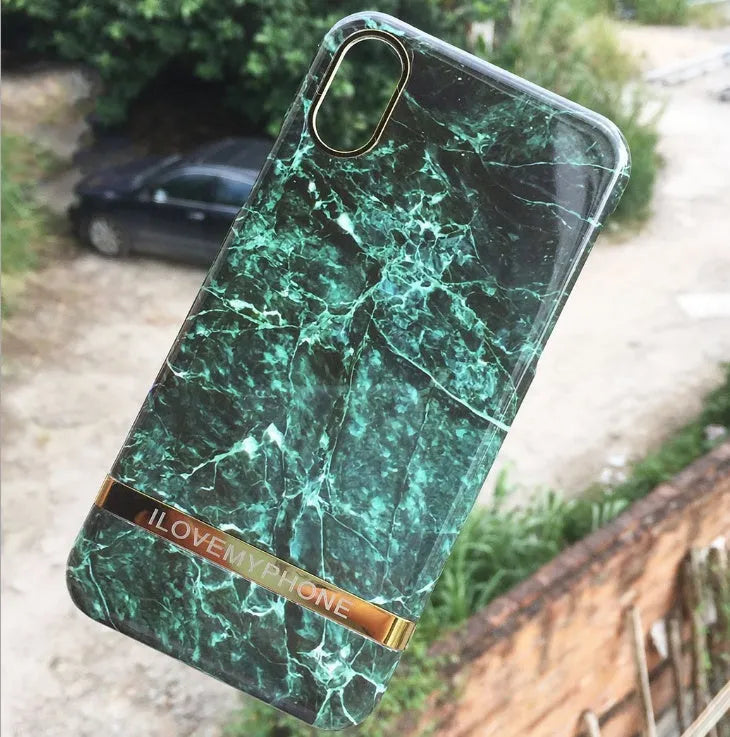 Plastic iPhone case with abstract marble pattern print in multiple colour options on a wooden table.