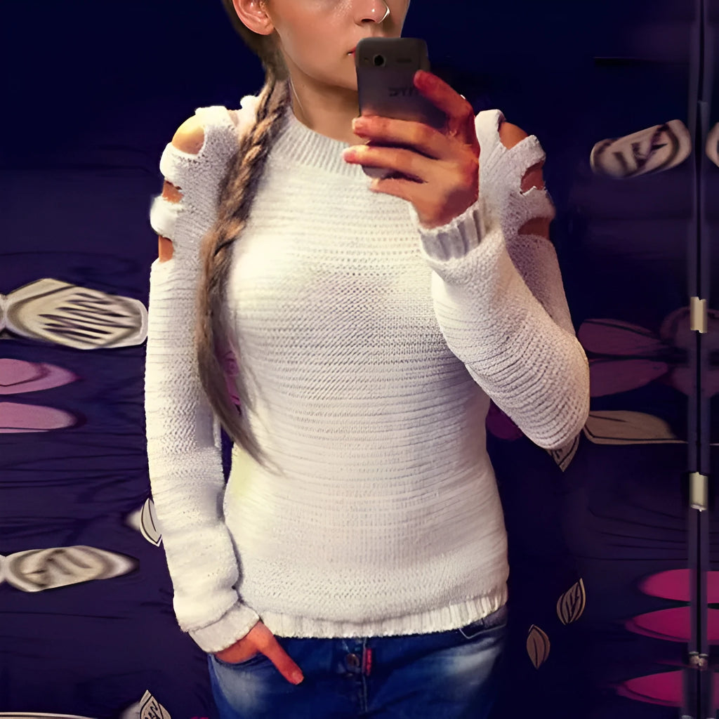 White women's knitted long sleeve shirt with hollow-out crochet detail on a hanger.