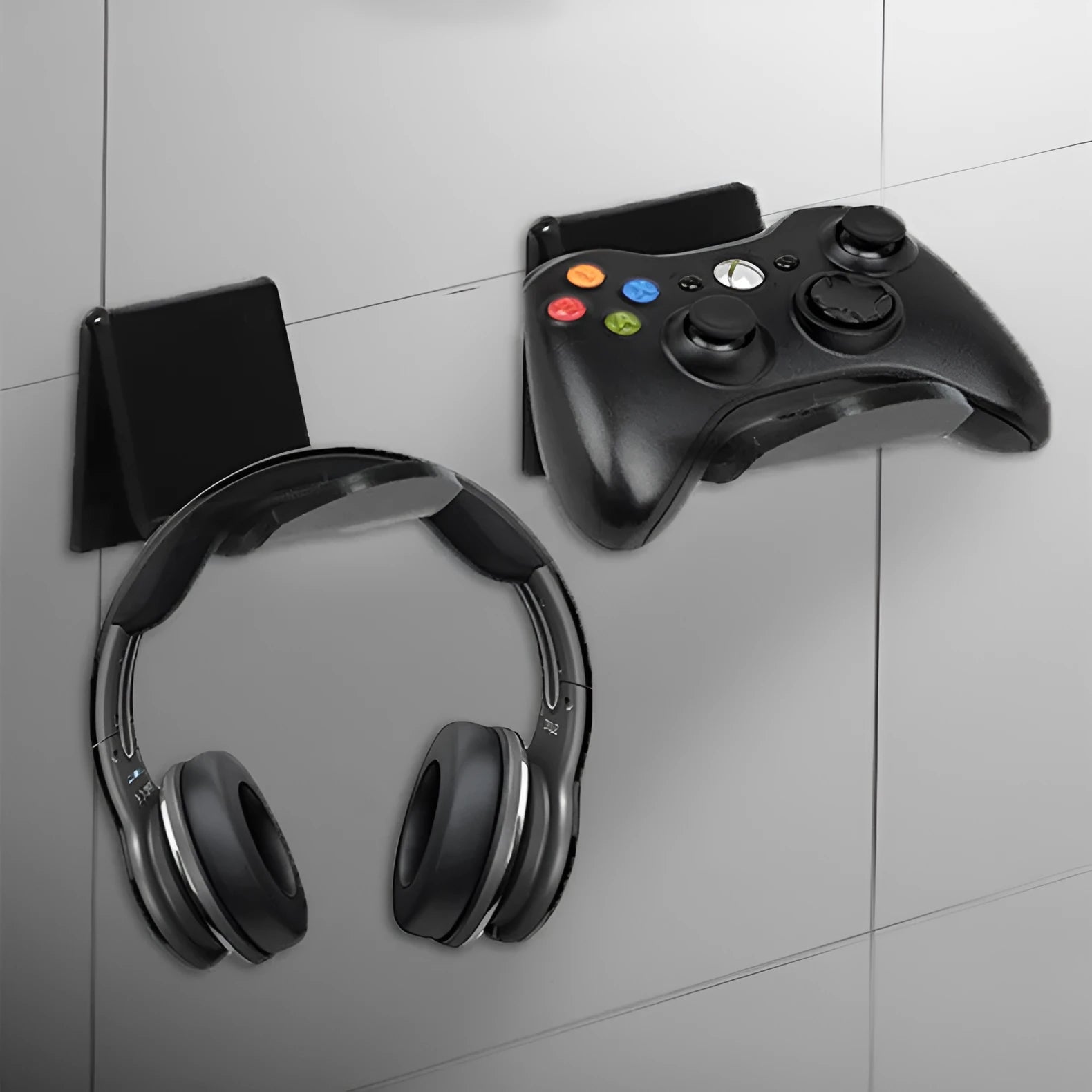Universal black game controller wall bracket mounted on a wall holding a PlayStation controller.