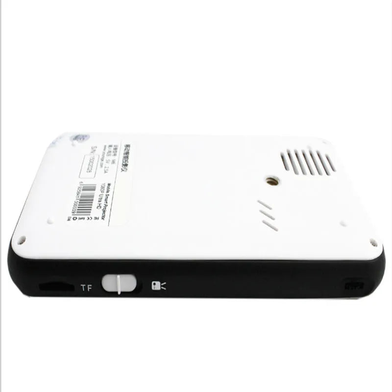 White smart handheld projector with Android system, DLP technology, wireless projection capability, placed on a table