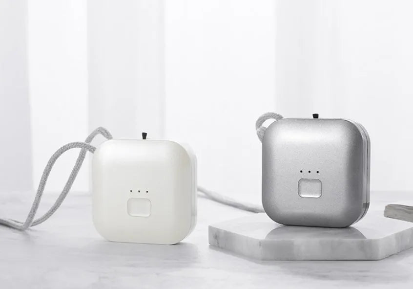 Pink portable USB air purifier necklace with charging cable showing compact wearable design