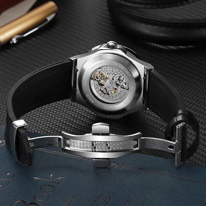 Men's automatic wristwatch with hollow dial showing mechanics, diamond studs on white case, on a black strap.