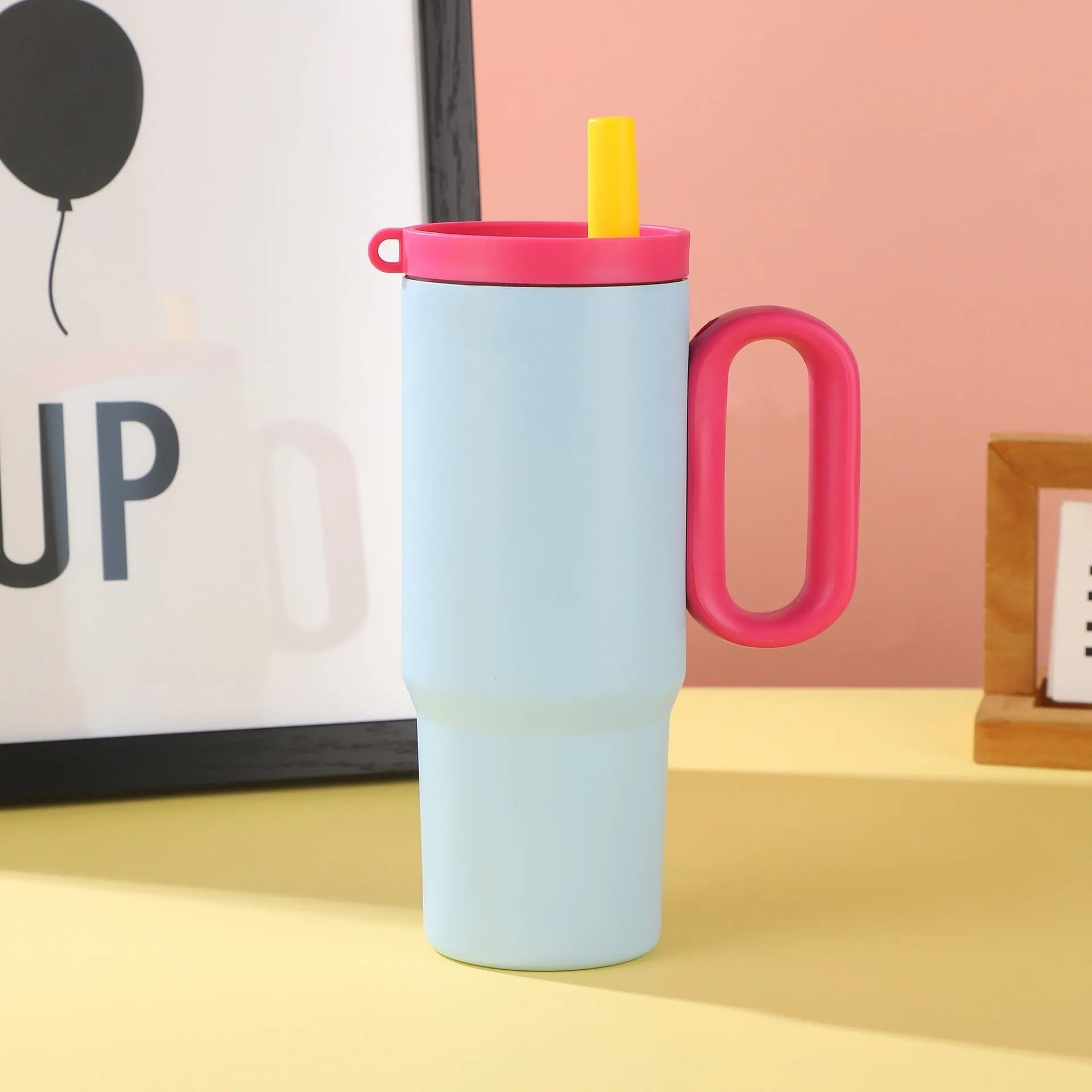 A large insulated portable cup with a handle, shown in multiple colour options.