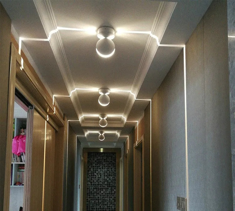 Modern aluminium spotlight bar wall lamp with glass lens, mounted on a wall.