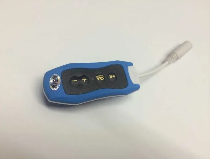 Compact black waterproof MP3 player earphone with USB cable, shown next to a ruler for scale.