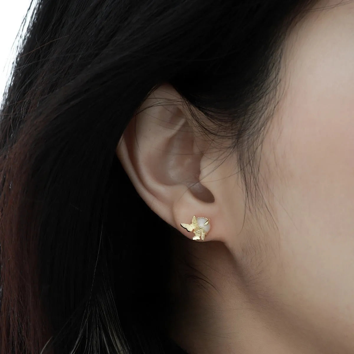 A pair of butterfly-shaped stud earrings in sterling silver with gold colour finish.