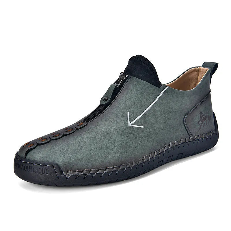 Men's black leather ankle boots with a front zip and hand-stitched detailing on a rubber sole.