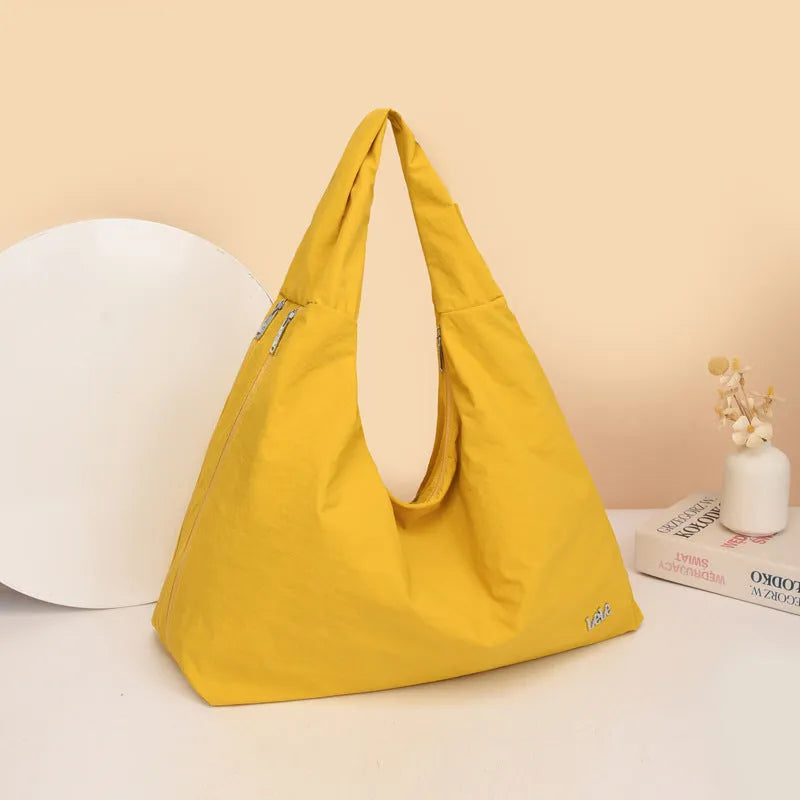 Soft heart-shaped nylon underarm bag for women shown in black, blue, khaki, and yellow.