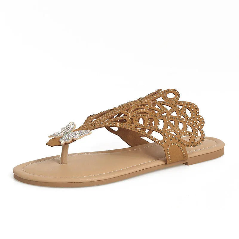 Women's black slip-on sandals with rhinestone decoration and an open flip-toe design on a flat rubber sole.