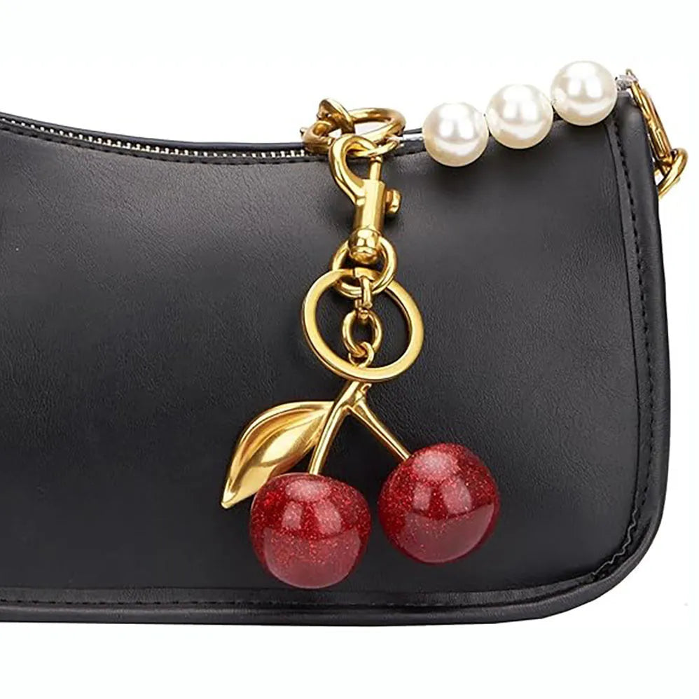 Close-up of a red zinc alloy keychain pendant with a three-dimensional cherry design.