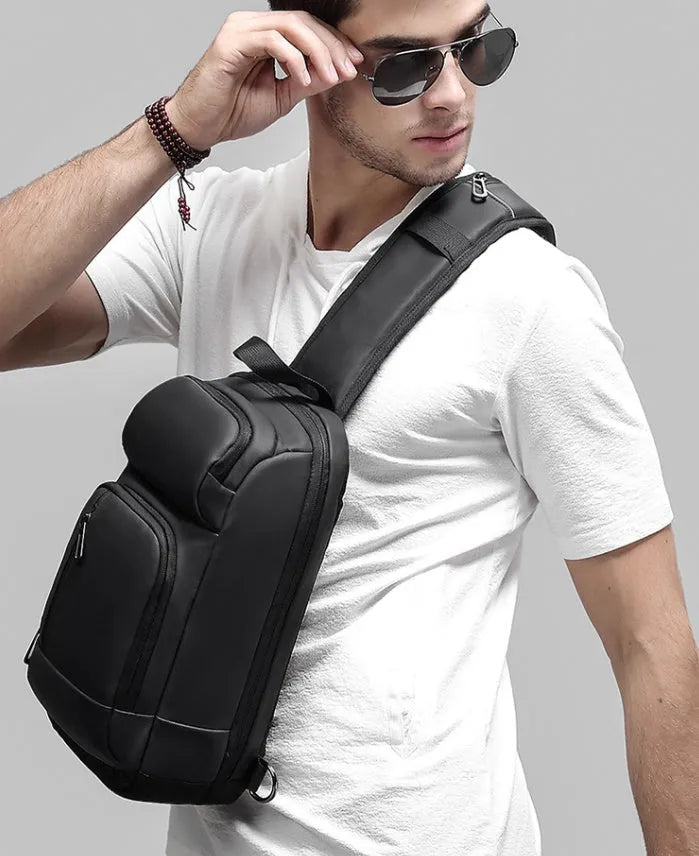 Black medium-sized PVC shoulder bag showing front zipper, air cushion strap, and internal laptop pocket.