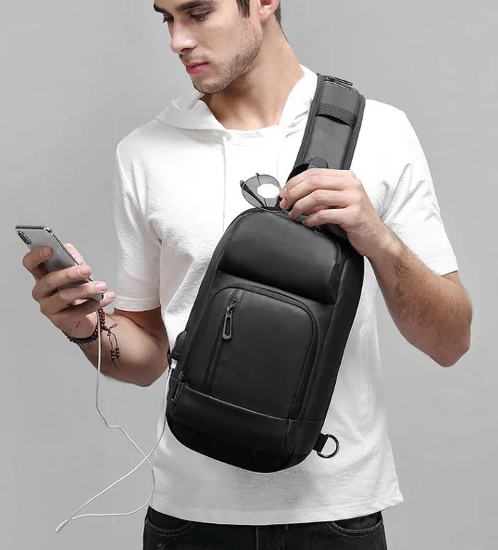 Black medium-sized PVC shoulder bag showing front zipper, air cushion strap, and internal laptop pocket.
