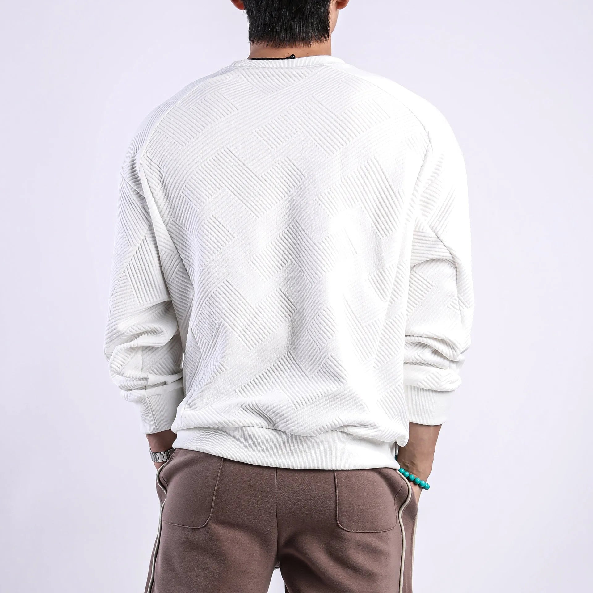 Men's loose fit solid colour twill jacquard pullover sweater on a hanger.