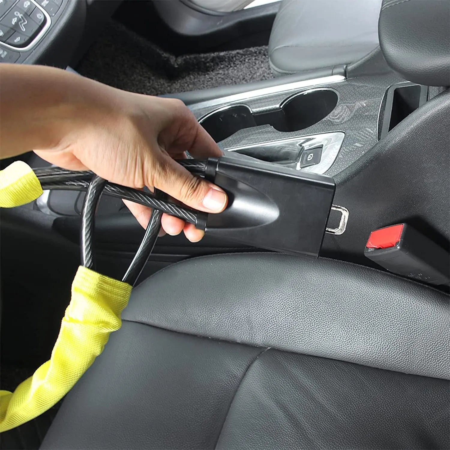 Red iron car steering wheel lock with wire rope for General Motors vehicles on a steering wheel.
