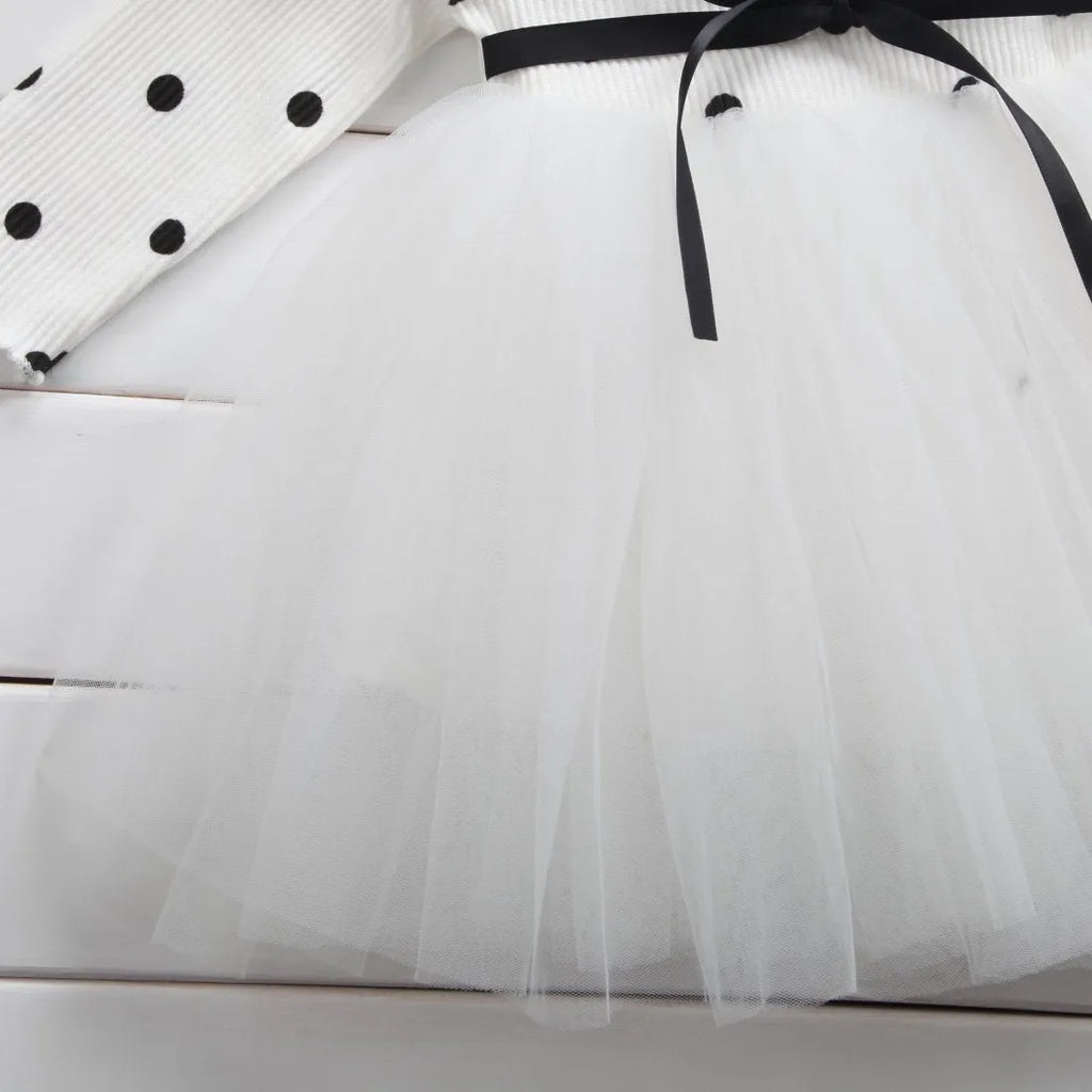 Baby girl wearing a long sleeve black tutu lace dress for a first birthday party.