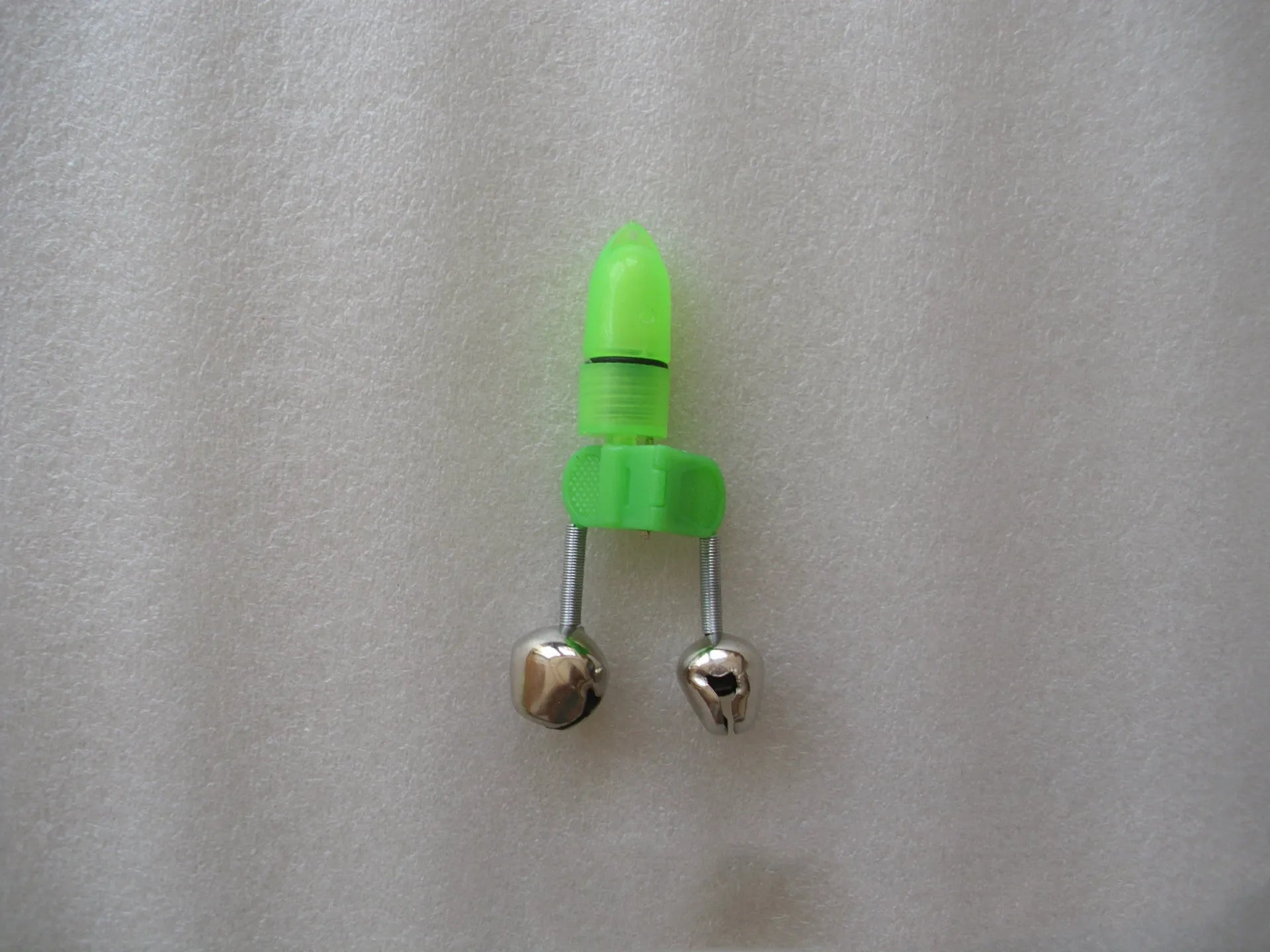 Two fishing bell bite alarms with LED lights, one green one red, clipped onto a fishing rod tip