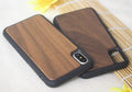 Wooden iPhone case with carbonised bamboo back and black TPU bumper frame on a wooden table.