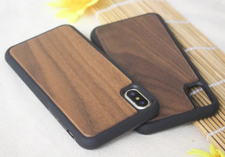 Wooden iPhone case with carbonised bamboo back and black TPU bumper frame on a wooden table.