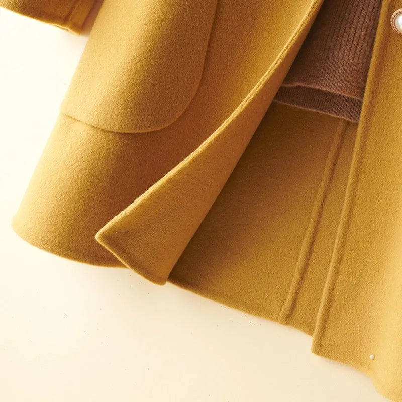 Women's solid colour wool coat with a doll collar and pearl buckle, shown in a mid-length cut.