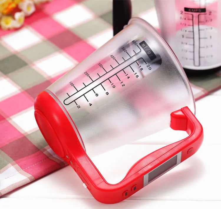 Green digital kitchen scale measuring cup with LCD display in handle on kitchen counter