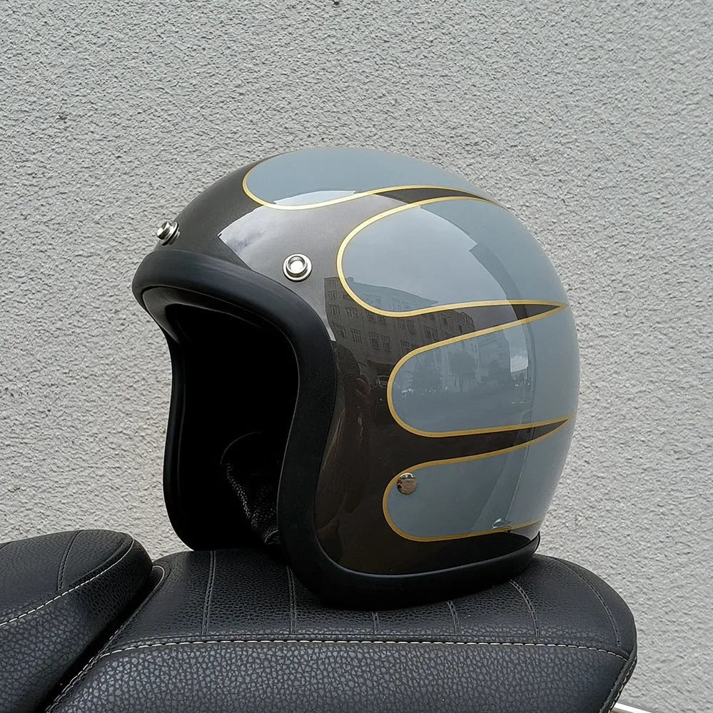 Retro-style open-face motorcycle helmet in fibreglass, shown in a choice of colours including Cement Grey and Matte Black Flower.