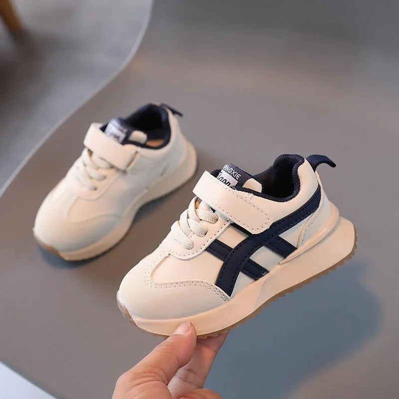 Children's solid-colour sneakers with Velcro strap closure and rubber sole.