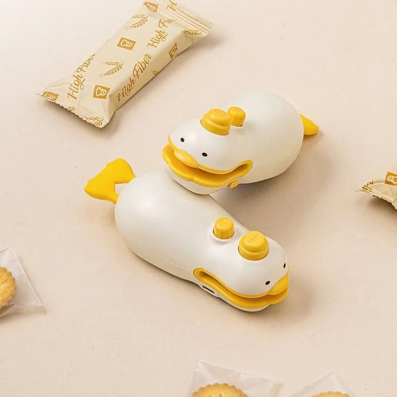 Small yellow rechargeable sealing machine with animal jacquard pattern and charging cable.