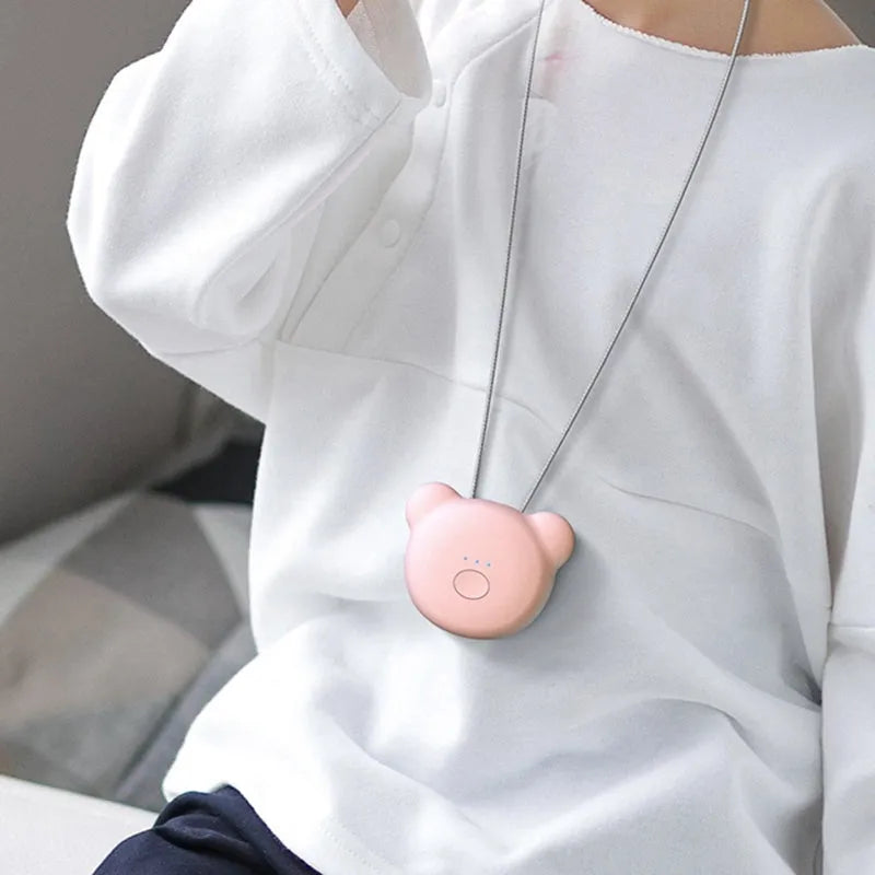 Pink portable USB air purifier necklace with charging cable showing compact wearable design