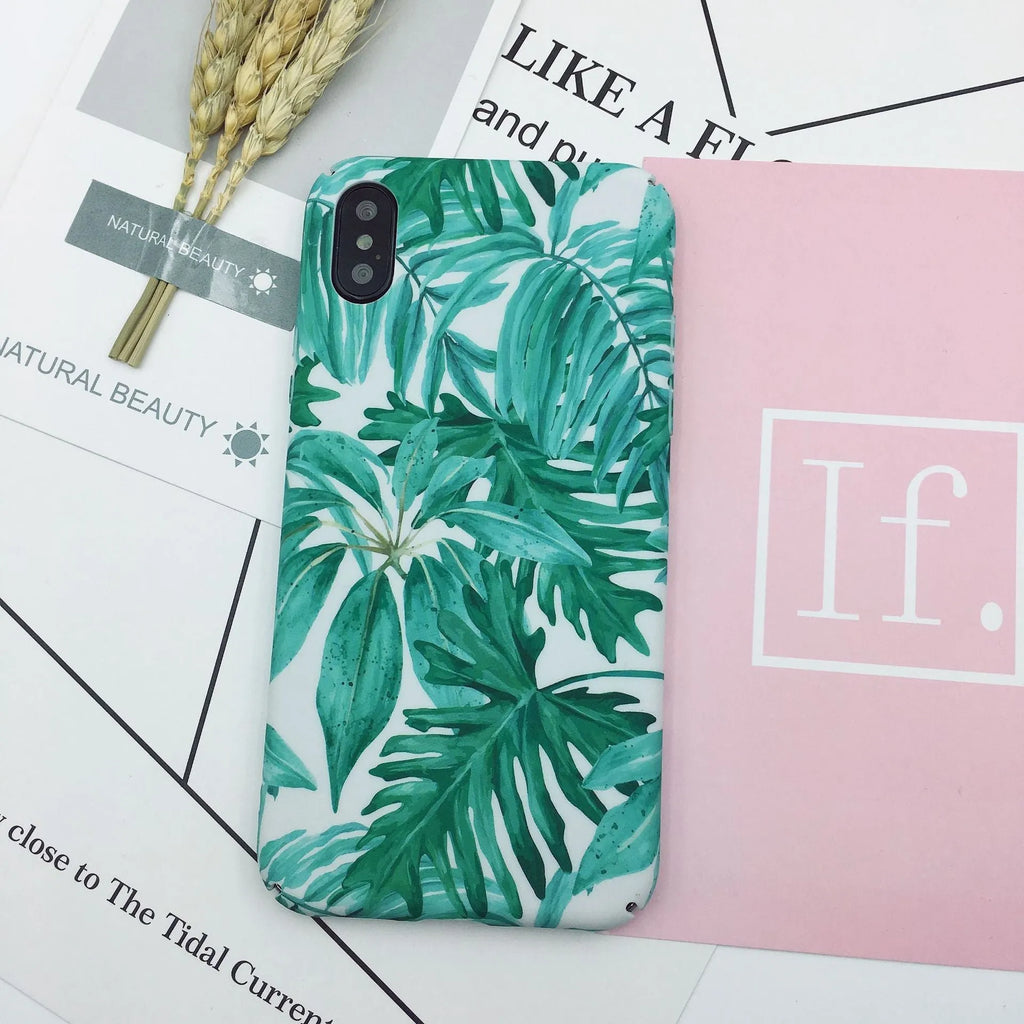 Green and pink painted hard PC back cover cases for smartphones on a table.