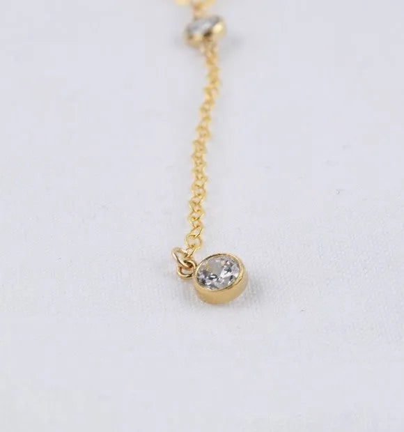 Gold alloy snake bone chain necklace with geometric pendant on display