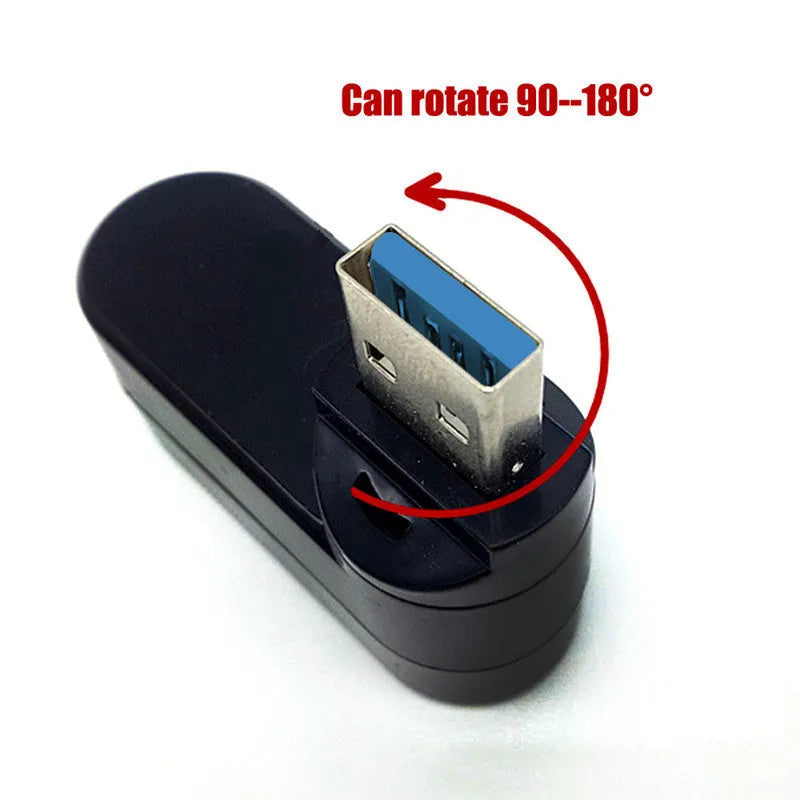 Black USB 3.0 four-port rotary hub on a desk next to a laptop, showing its compact size and rotating design.