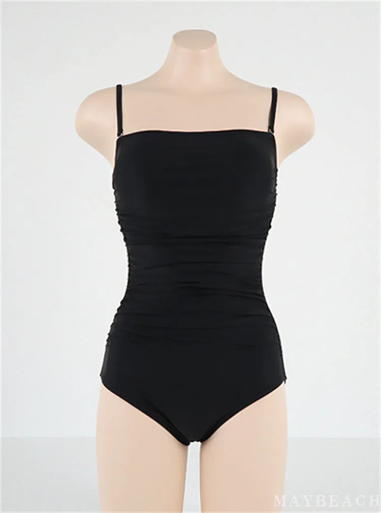 Blue sling style one-piece swimsuit with belly pleating on a model