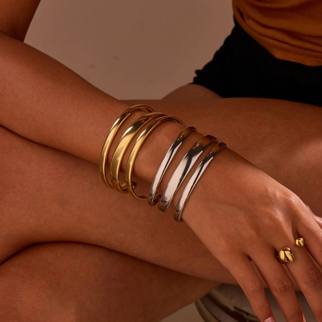 Geometric line design stainless steel bracelet with simple opening clasp, shown in gold and steel colour options.
