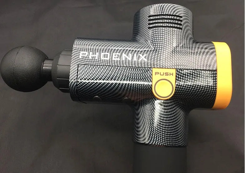 A black or silver ABS plastic percussion massage gun with four different removable massage heads on a table.