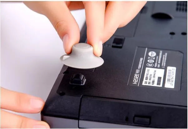 Four grey durable plastic laptop cooling pads, two large and two small, placed on a desk surface.