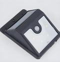 Two white solar-powered motion sensor security lights mounted on a dark wall, with adjustable lamp heads and solar panels.