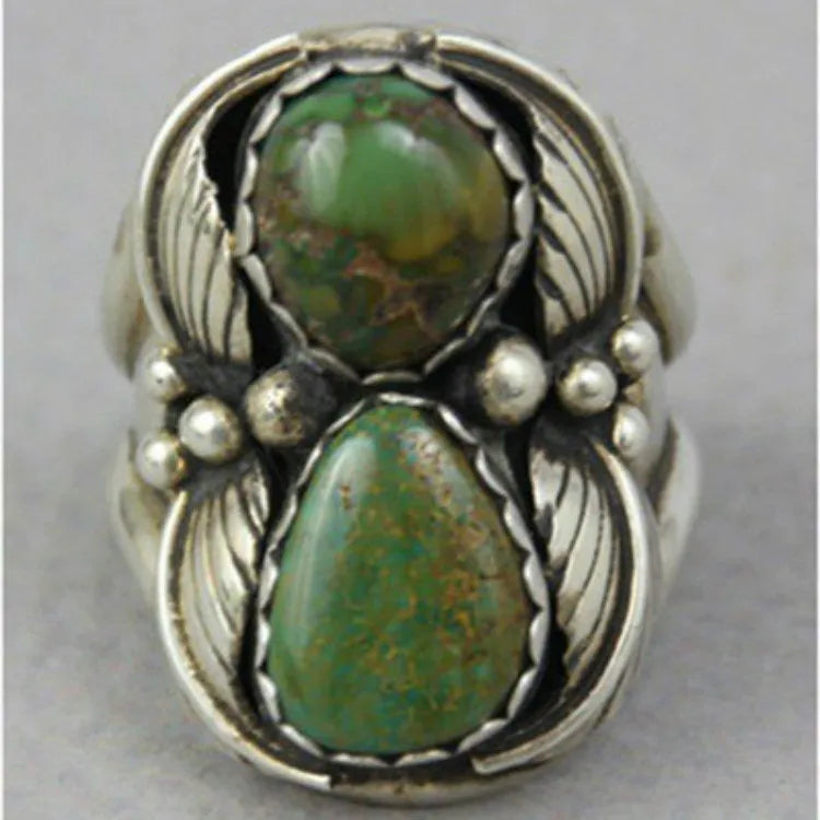 Close-up of a women's geometric ring with a retro turquoise inlay on a grey background.