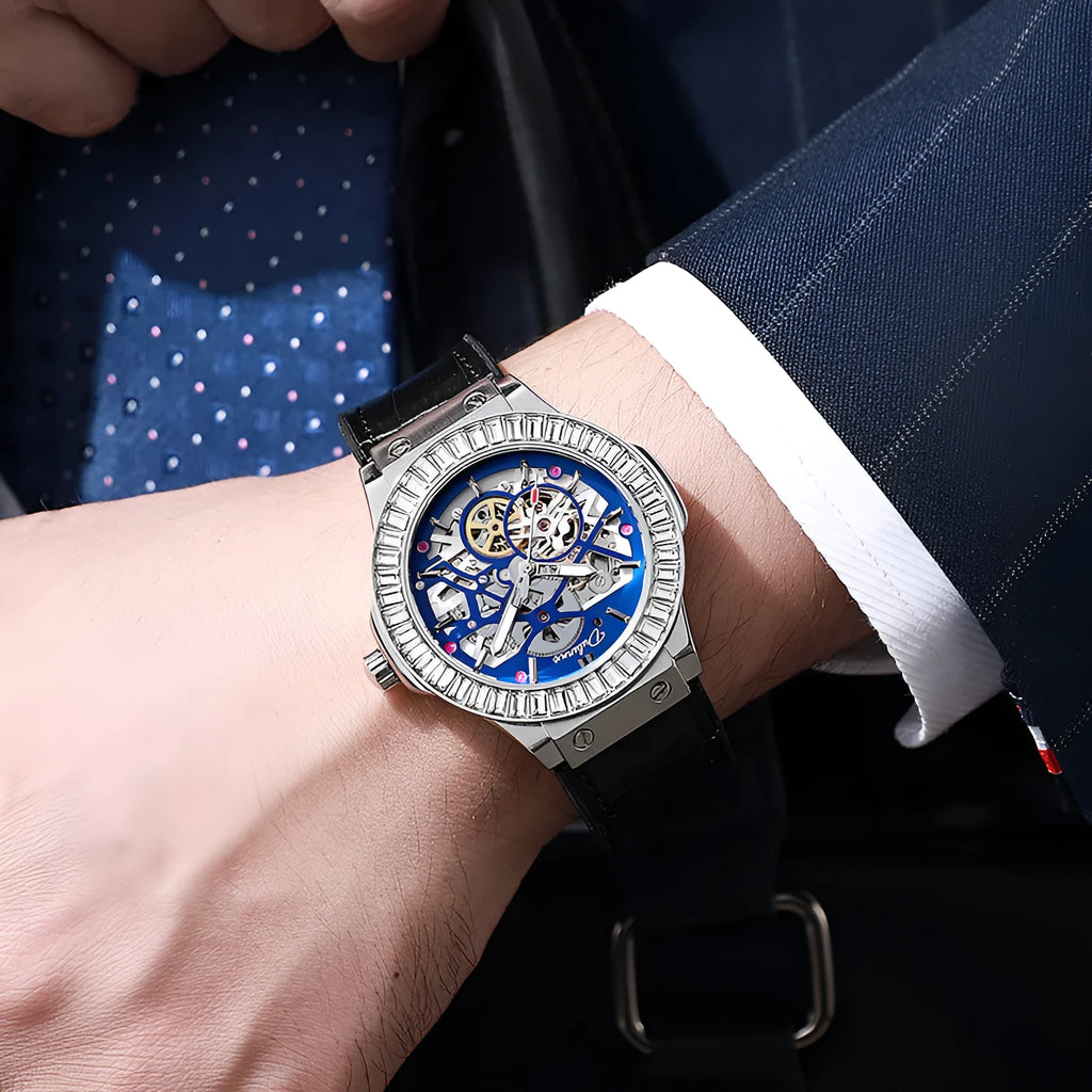 Men's automatic wristwatch with hollow dial showing mechanics, diamond studs on white case, on a black strap.