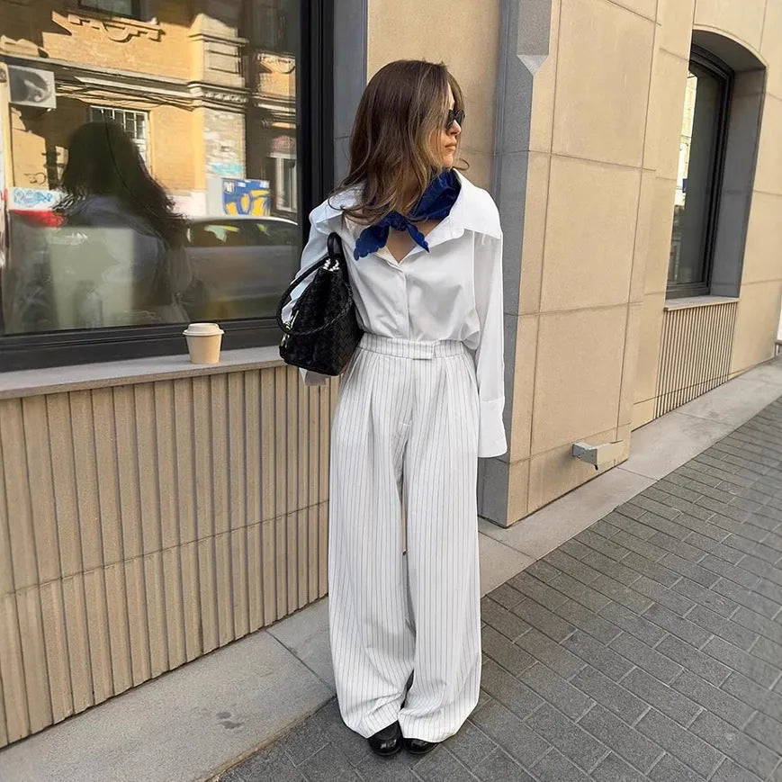 White striped wide-leg casual trousers with a zipper detail on a hanger.
