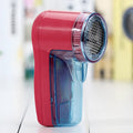 Blue portable electric lint remover for clothing on a white background.
