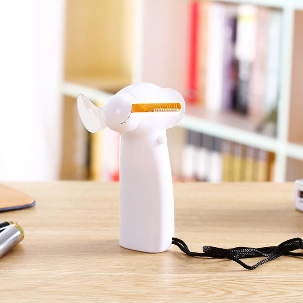 White handheld mini fan with LED lights displaying a love heart pattern, shown next to AAA batteries for scale.