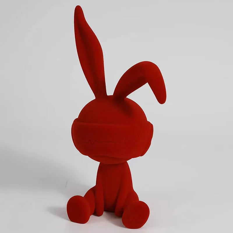 Green suede-finish resin ornament of a blindfolded rabbit for table decoration.