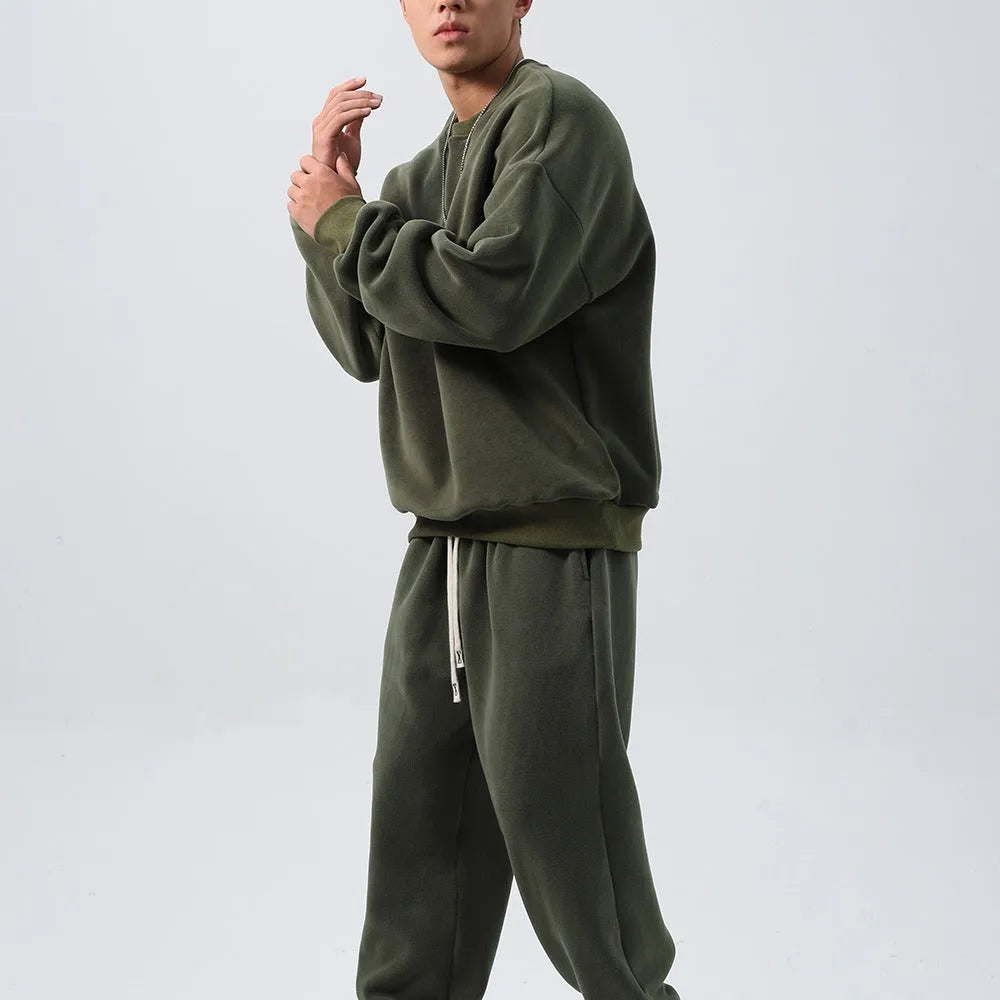 Man wearing a loose black polar fleece winter sports suit with crew neck coat and trousers